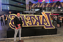 Myles stands in front of the Lakers sign at the Staples Center.