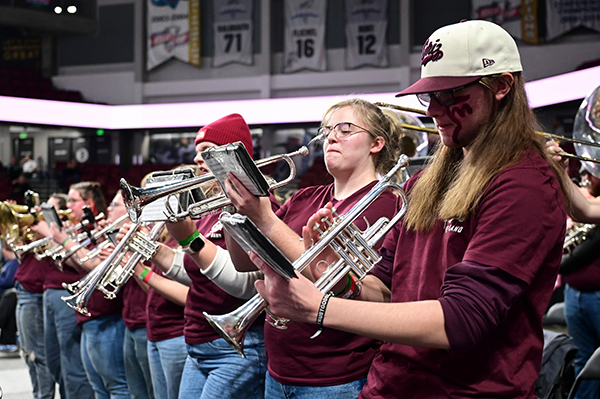 UM musicians play trumpets at a basketball game